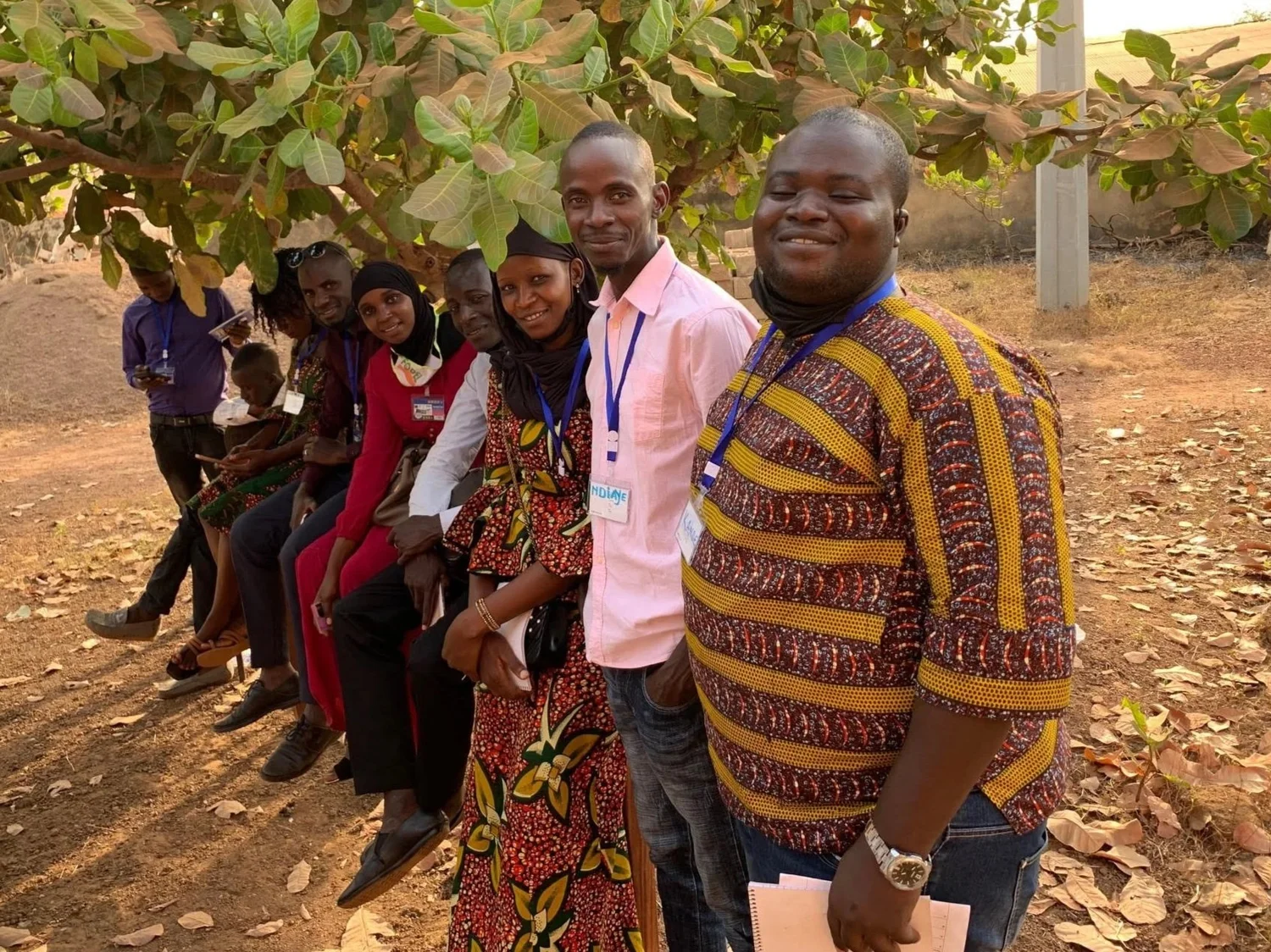A group of people standing together outdoors under trees
